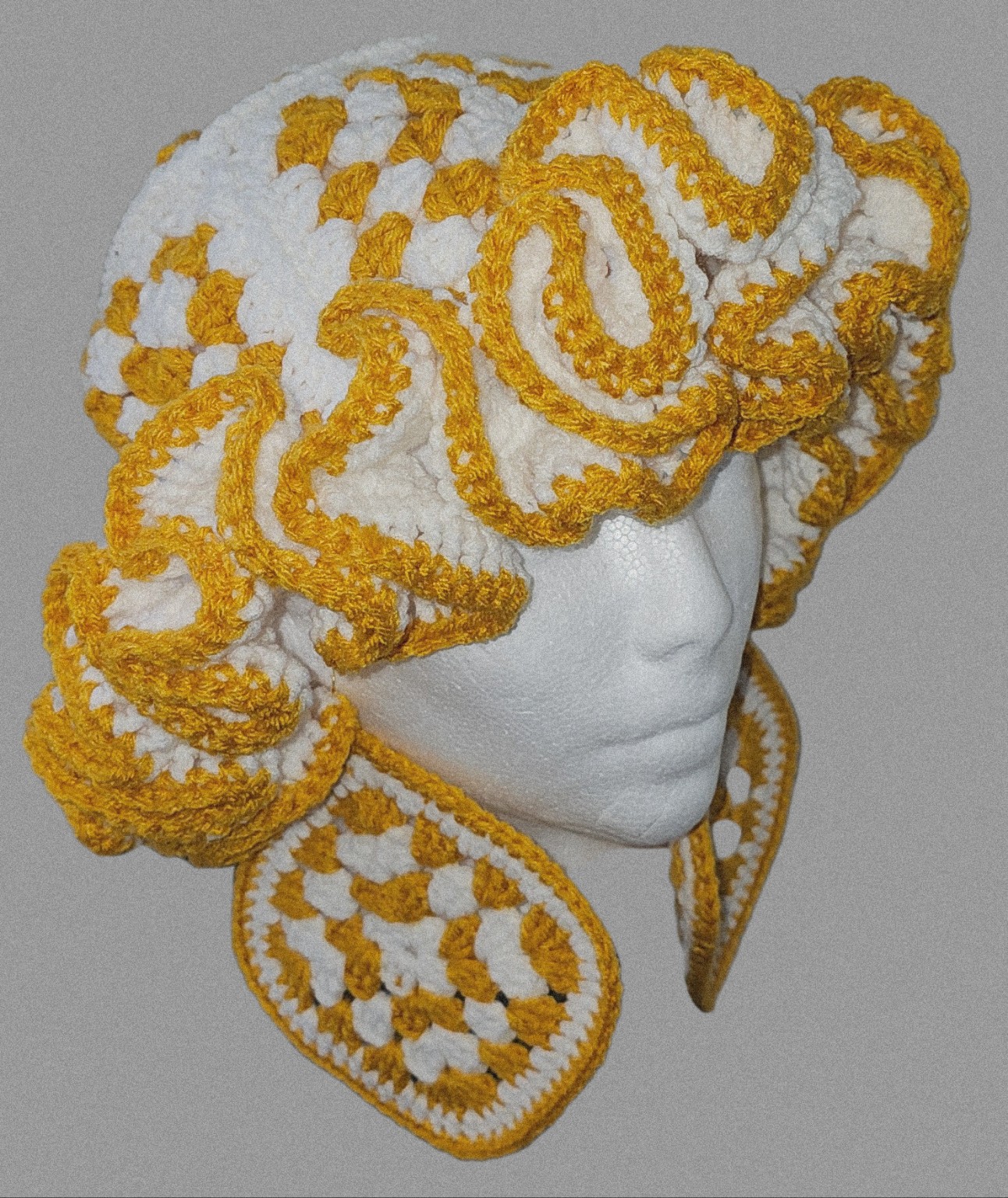 Gold and white large-ruffle crochet hat styled with coordinating crochet earrings